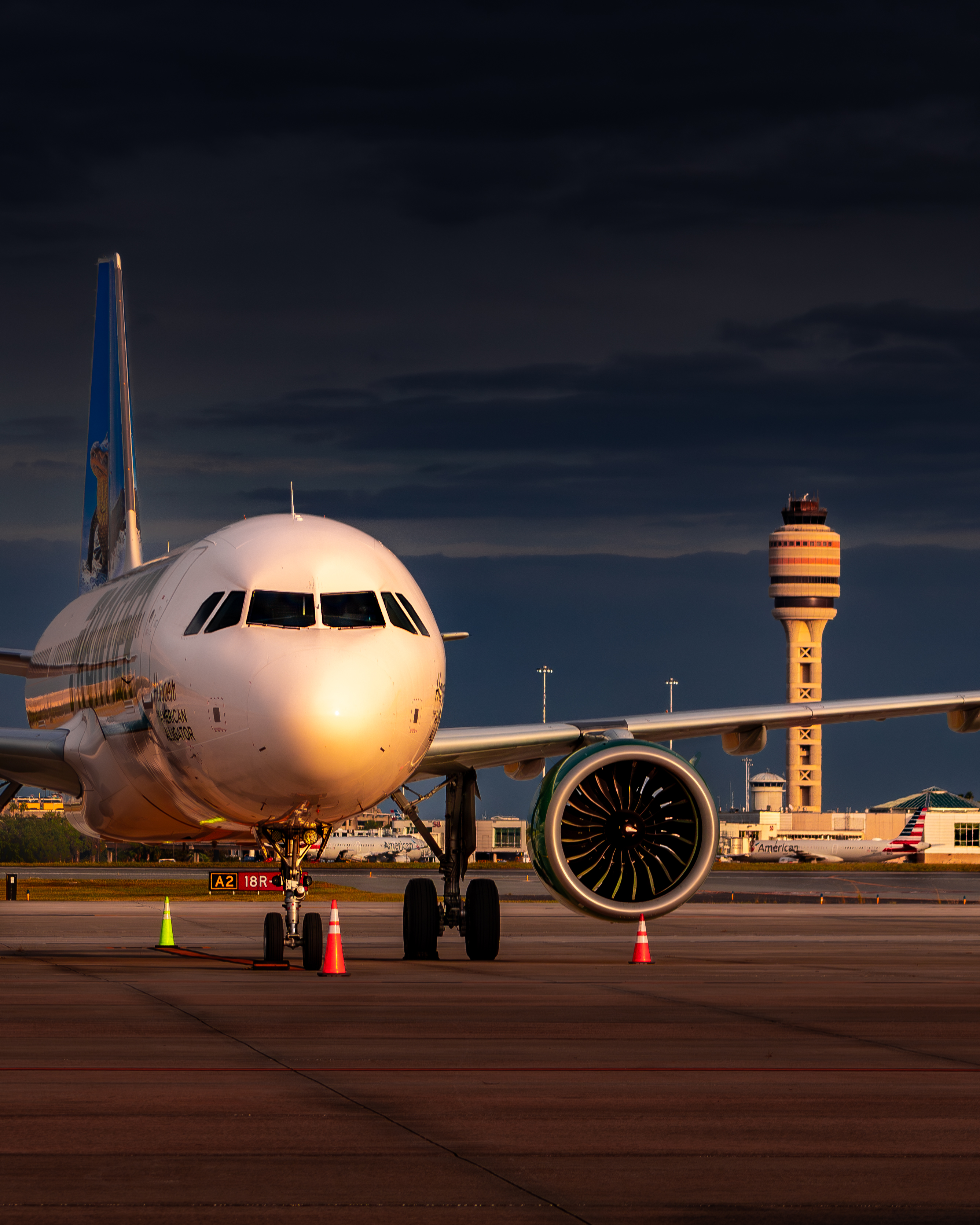 Frontier Airlines Airbus A320 at gate with MCO ATC tower in background