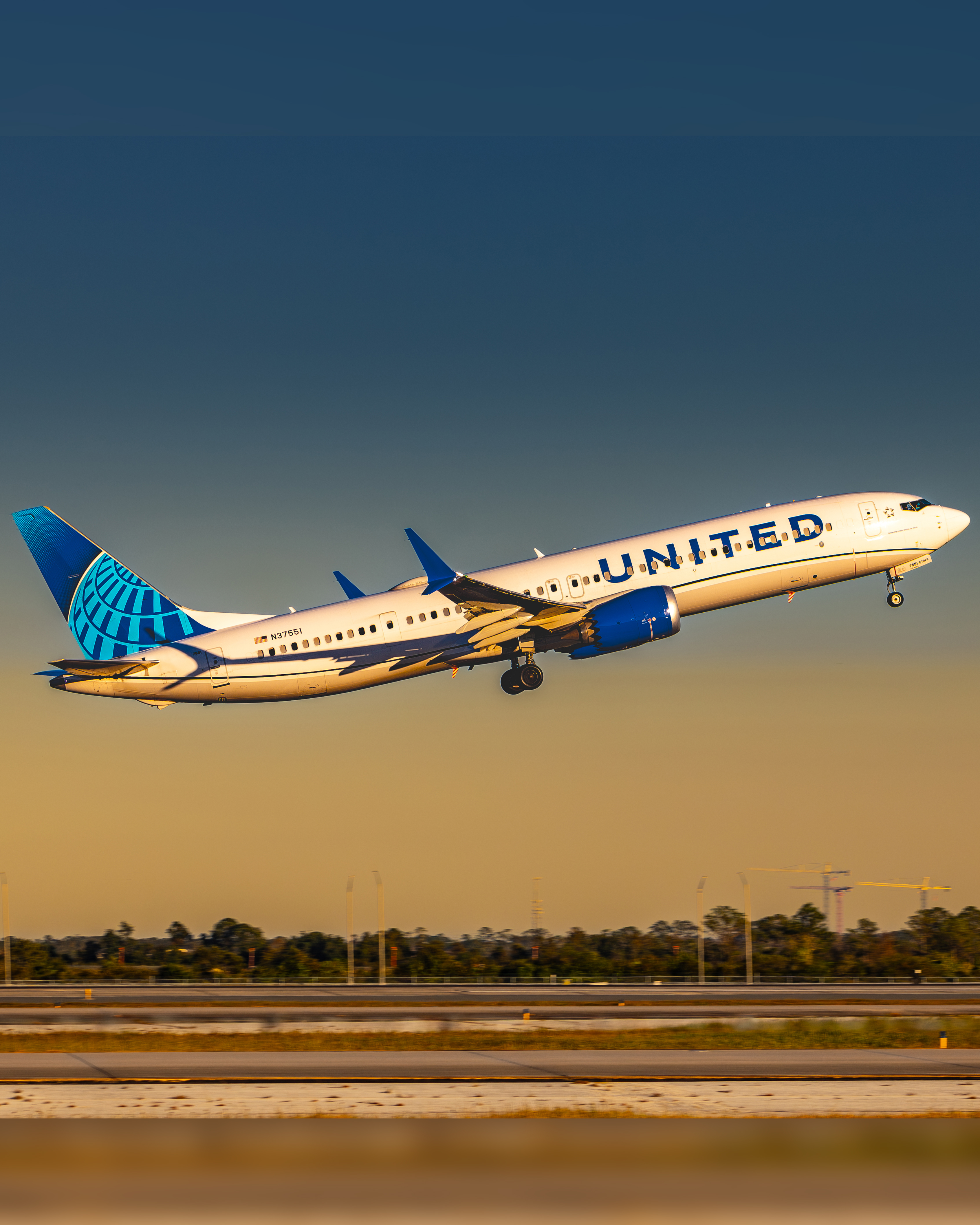 United Airlines Boeing 737-900 taking off at golden hour